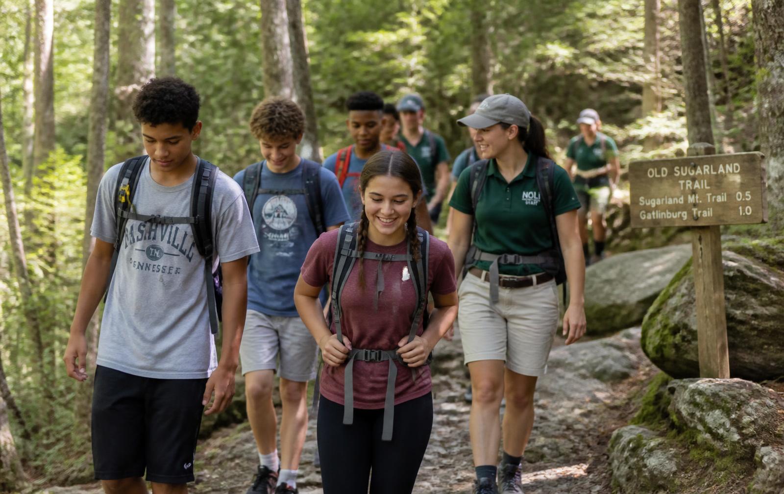 Group of young hikers climbing a wooded Tennessee ridge trail